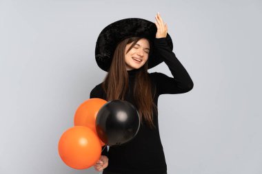 Siyah ve turuncu hava balonları tutan genç cadı bir şeyin farkına vardı ve çözüme niyetlendi.