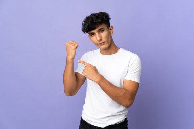 Arjantinli genç adam arka planda izole edilmiş, geç kalma jesti yapıyor.