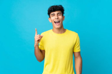 Arjantinli genç adam arka planda izole edilmiş yukarı bakıyor ve şaşırıyor