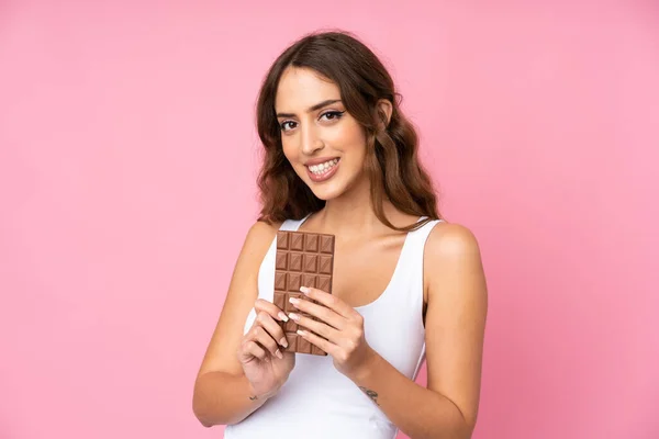 Mladá Žena Nad Izolované Růžové Pozadí Čokoládovou Tabletu Šťastný — Stock fotografie