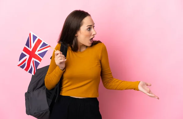 年轻的惊慌失措的女人一边举着英国国旗 一边惊讶地看着旁边 — 图库照片