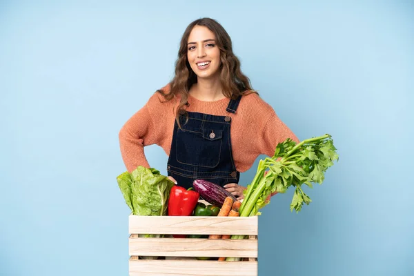 Rolnik Świeżo Zebranymi Warzywami Pudełku Pozującym Rękami Biodrze Uśmiechniętym — Zdjęcie stockowe