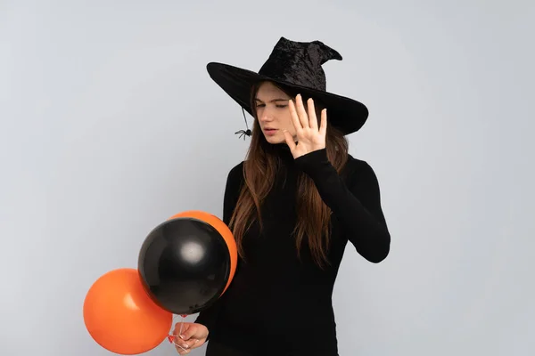 黒とオレンジの気球を保持若い魔女作る停止ジェスチャーと失望 — ストック写真