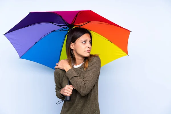 Ung Brunett Kvinna Håller Ett Paraply Över Isolerad Blå Vägg — Stockfoto
