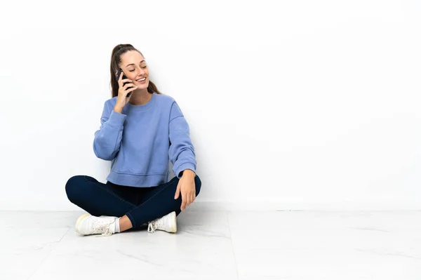 Mujer Joven Sentada Suelo Manteniendo Una Conversación Con Teléfono Móvil — Foto de Stock