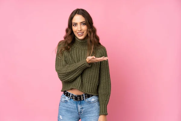 Mujer Joven Sobre Fondo Rosa Aislado Presentando Una Idea Mientras —  Fotos de Stock