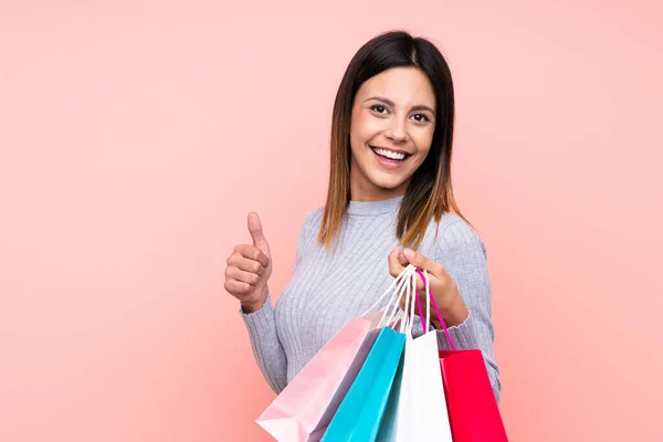 Mujer Sobre Fondo Rosa Aislado Sosteniendo Bolsas Compras Con Pulgar —  Fotos de Stock