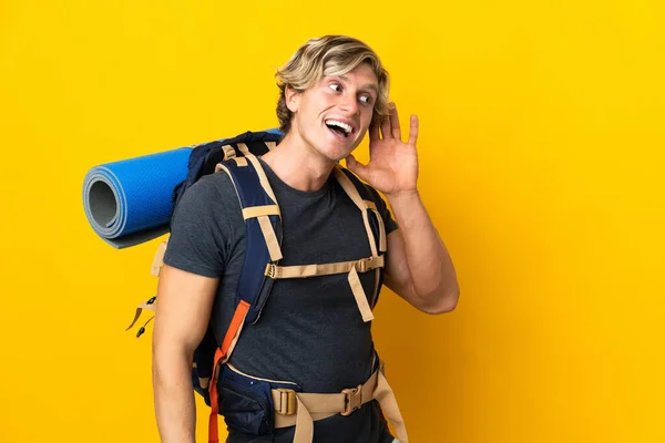 Jeune Alpiniste Homme Sur Fond Jaune Isolé Écoutant Quelque Chose — Photo