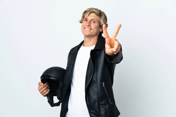 英語男保持Aオートバイヘルメット笑顔とショーの勝利サイン — ストック写真