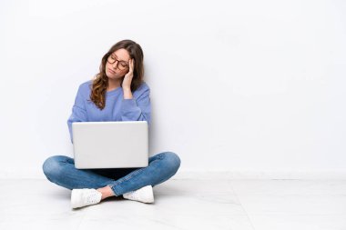 Dizüstü bilgisayarı olan, beyaz arka planda izole edilmiş, başı ağrıyan genç, beyaz bir kadın.