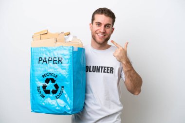 Beyaz arka planda izole edilmiş bir şekilde geri dönüşüm için elinde kağıt dolu bir torba tutan beyaz bir adam baş parmak hareketi yapıyor.