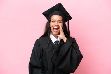 Kolombiyalı genç bir üniversite mezunu pembe arka planda ağzı açık bağırıyor.