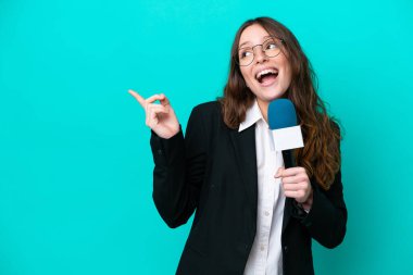 Genç TV sunucusu kadın, mavi arka planda izole edilmiş bir şekilde parmağını kaldırarak çözümü anlamaya çalışıyor.