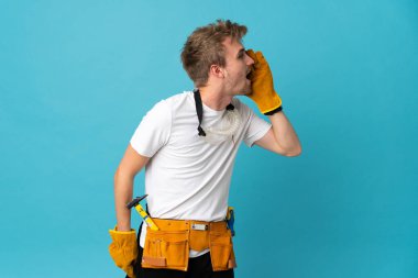 Genç elektrikçi yalıtılmış duvarın üzerinden ağzı açık bağırıyor.