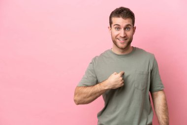 Pembe arka planda yalıtılmış beyaz bir adam. Şaşırtıcı bir yüz ifadesi var.