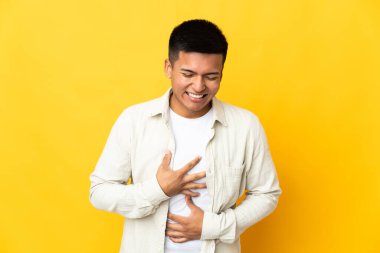 Young Ecuadorian man isolated on yellow background smiling a lot