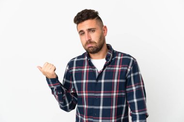 Caucasian man isolated on white background unhappy and pointing to the side