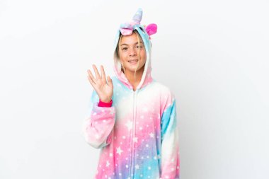 Little girl with unicorn pajamas isolated on white background saluting with hand with happy expression