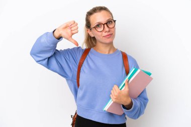 Beyaz arka planda izole edilmiş beyaz tenli genç bir kadın, olumsuz bir ifadeyle baş parmağını aşağı gösteriyor.