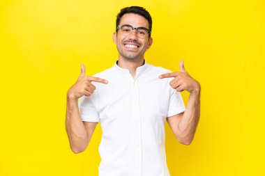 Genç yakışıklı, soyutlanmış sarı arka plan gururlu ve kendini beğenmiş.