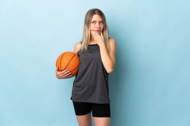 Young blonde woman playing basketball isolated on blue background thinking an idea