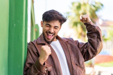 Dışarıda zaferi kutlayan yakışıklı bir Arap.