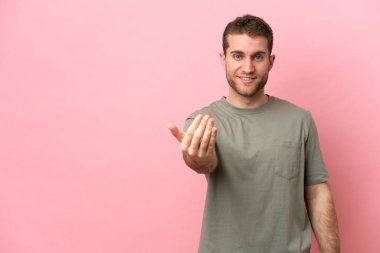 Pembe arka planda izole edilmiş genç beyaz bir adam, bizimle gelmesi için davet ediyor. Gelmene sevindim.