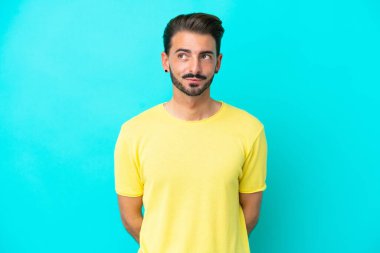 Kafkasyalı genç adam mavi arka planda izole edildi.