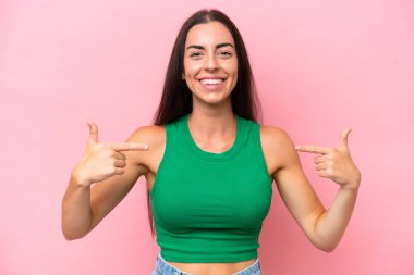 Genç beyaz kadın pembe arka planda soyutlanmış gururlu ve kendini beğenmiş.