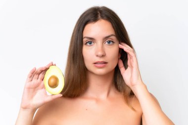 Beyaz arka planda avakado tutan beyaz bir kadın. Portreyi kapat