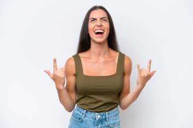Beyaz arka planda izole edilmiş genç beyaz kadın boynuz hareketi yapıyor.