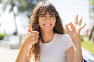 Dışarıdaki genç kadın gözlüklü ve iyi bir işaret yapıyor.