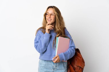 Beyaz arka planda izole edilmiş genç bir bayan. Yan tarafa bakıyor ve gülümsüyor.