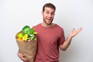 Beyaz arka planda izole edilmiş bir alışveriş torbası tutan beyaz bir adam.