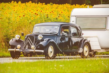 Retro Vintage Citroen çekiş Avant karavan ile görüntüsünü Dieren, Hollanda çiçek açan ayçiçeği olan bir alana önünde yerel bir yolda tarz