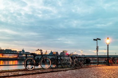 Akşam görünümü Hollandalı Maastricht şehir Maas Nehri yanında park edilmiş Bisiklet