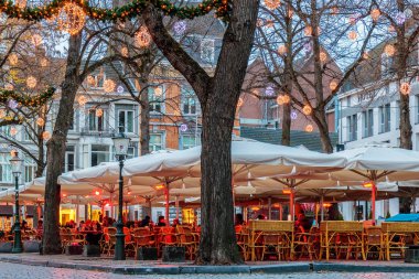Akşam yemeği tablolar bar ve restoran ile Noel ışıkları ünlü Onze Lieve Vrouweplein Meydanı'Maastricht, Hollanda