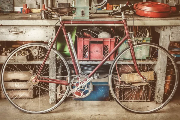 Bicicleta de carreras vintage frente a un antiguo banco de trabajo con herramientas —  Fotos de Stock