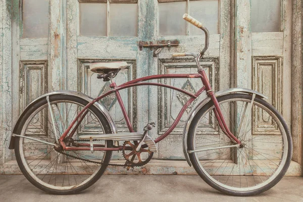 Vintage krążownik plażowy przed zabytkowymi drzwiami drewnianymi — Zdjęcie stockowe