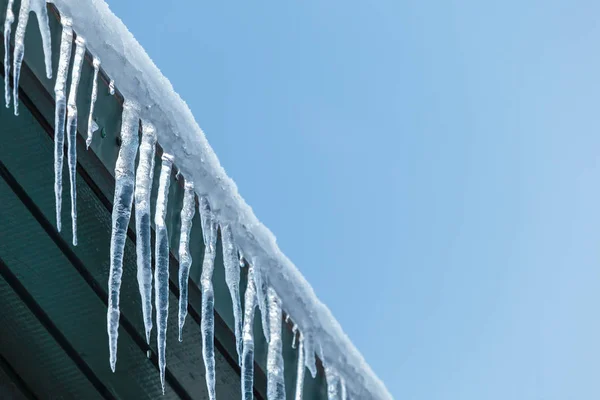 Hanging icicles on a roof — Stock Photo, Image