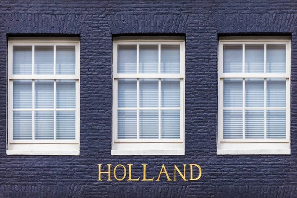 Windows of an Amsterdam canal house with the text Holland