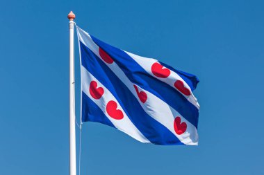 Açık mavi gökyüzüne karşı Hollanda Frizya bayrağı