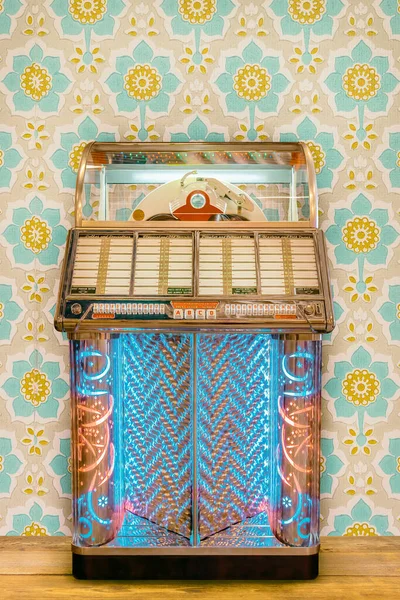 Πολύχρωμο Vintage Jukebox Μπροστά Από Ρετρό Ταπετσαρία Λουλουδιών Ξύλινο Πάτωμα — Φωτογραφία Αρχείου