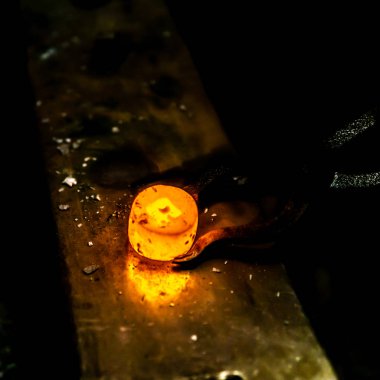 Hot und glow iron workpiece during work in a blacksmith. clipart
