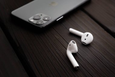 Belgrad, Sırbistan - Ağustos 2020, Apple AirPods 2 ve iPhone 11 Pro tahta zemin
