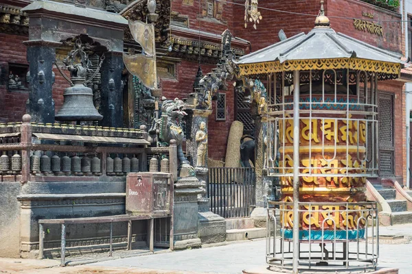 Ornate religious objects await worshippers at the front of a Buddhist temple in Patan, Nepal