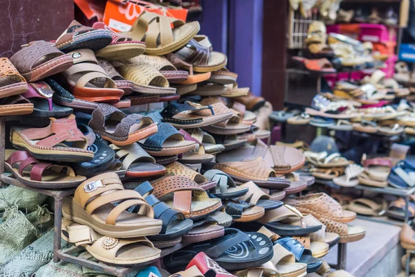 A mixed pile of no-brand shoes in a traditional marketplace in a foreign country