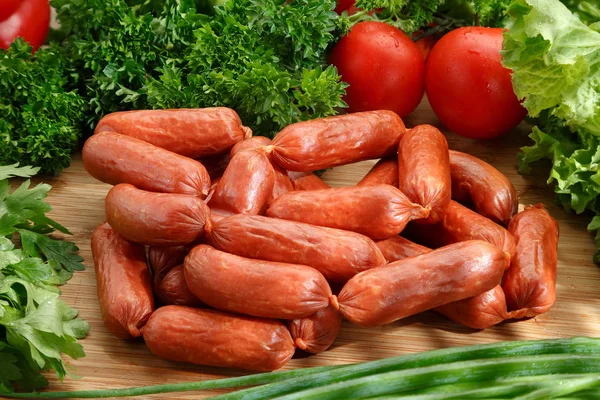 Sausage Lies Wooden Table Background Vegetables Greens — Stock Photo, Image