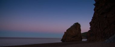 Playa con rocas y cielo con efectos de la fotografa