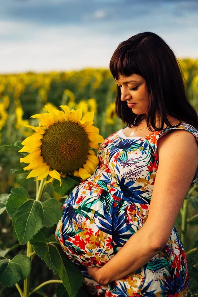 Grande imagem de uma mulher grávida em um campo de girassóis — Fotografia de Stock